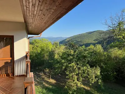 a balcony of a house with a view of the mountains at The Old Walnut House in Terziysko