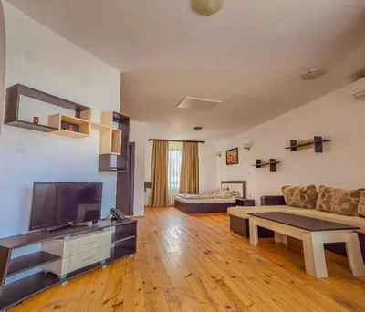 a living room with a couch and a flat screen tv at Everwood Hotel & Restaurant in Govedartsi