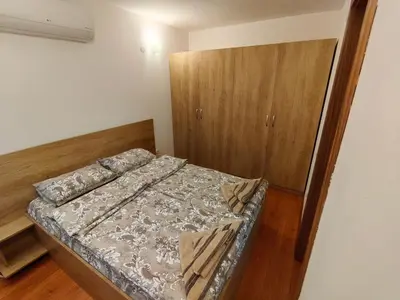 a small bedroom with a bed and a cabinet at Апартамент Мария in Bansko