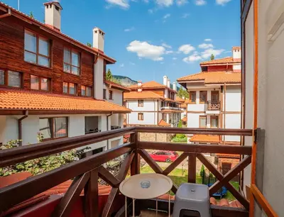 a balcony with a table and chairs and buildings at Oxygen Time in Smolyan