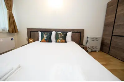 a bedroom with a large white bed with two pillows at Madzharovi Apartments in Borovets