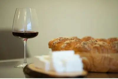 a glass of wine next to a loaf of bread at Madzharovi Apartments in Borovets