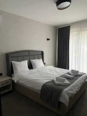 a bedroom with a bed with white sheets and pillows at Zlate Home in Zlatograd