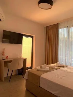 a bedroom with a bed and a desk and a window at Zlate Home in Zlatograd