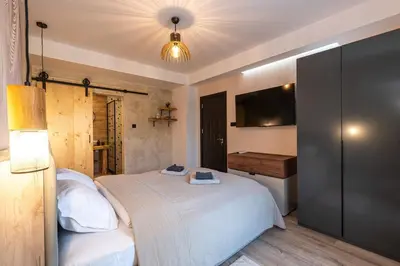 a bedroom with a large white bed and a desk at Vutovi's corner made with care 2 in Bansko
