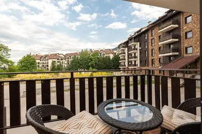 a balcony with two chairs and a table on a balcony at Vutovi's corner made with care 2 in Bansko