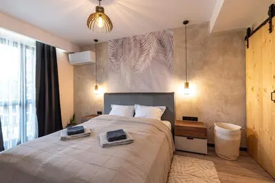 a bedroom with a large bed with two towels on it at Vutovi's corner made with care 2 in Bansko