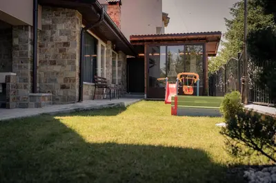 a house with a yard with a gate and a playground at Royal View Guest House in Dospat