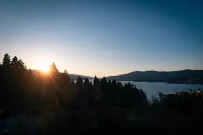 a sun setting over a body of water at Royal View Guest House in Dospat