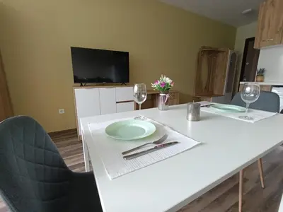 a white table with two plates and wine glasses at 20th Residence Studio 1 in Sofia
