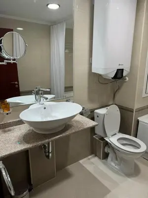 a bathroom with a sink and a toilet and a mirror at Downtown Bansko Resort in Bansko