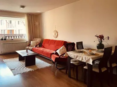 a living room with a red couch and a table at Mountain View Apartment at Bansko Royal Towers in Bansko