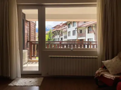 a door to a balcony with a view of a building at Mountain View Apartment at Bansko Royal Towers in Bansko
