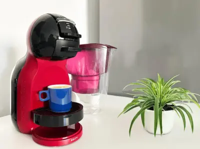a red coffee maker with a cup next to a plant at BudgetWork-Friendly Apartment near Business Park in Sofia