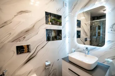 a white bathroom with a sink and a mirror at Luxe Apartment Pana Green Residence Panagyurishte in Panagyurishte
