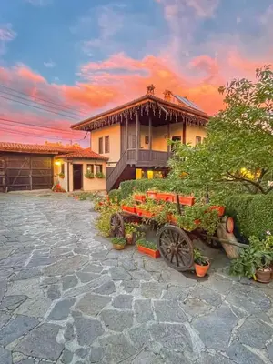 a house with a garden with a wagon in front of it at Luxe Apartment Pana Green Residence Panagyurishte in Panagyurishte