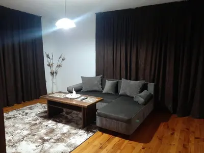 a living room with a couch and a table at Апартамент Ризови in Sandanski