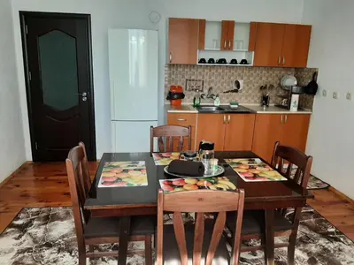 a kitchen with a dining room table with chairs and a tableablish at Апартамент Ризови in Sandanski