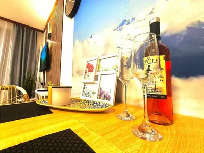 a table with two wine glasses and a bottle of wine at Grand studio in 4star SPA resort in Bansko in Bansko