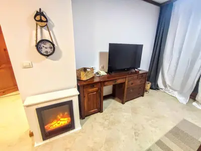 a living room with a television and a fireplace at Large 1bd apartment in 4star SPA resort Bansko in Bansko