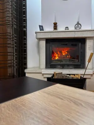 a fireplace with a table in front of it at Wood Fireplace Duplex near Pamporovo - Parking, Sleeps 6 in Smolyan