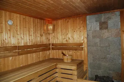 an empty wooden sauna with a bucket in it at Лари Б01 in Borovets