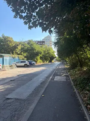 an empty street with cars parked in a parking lot at ApartSofiaMusagenica in Sofia