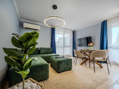 a living room with a green couch and a table at The Boulevard Luxury Apartment 3 in Sofia