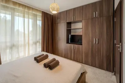 a bedroom with a bed with two brown towels on it at The Boulevard Luxury Apartment 3 in Sofia
