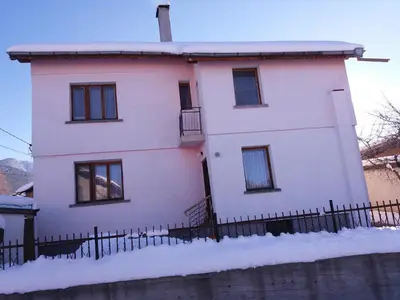 a white house with a fence in the snow at Guest House AHP in Mala Tsŭrkva