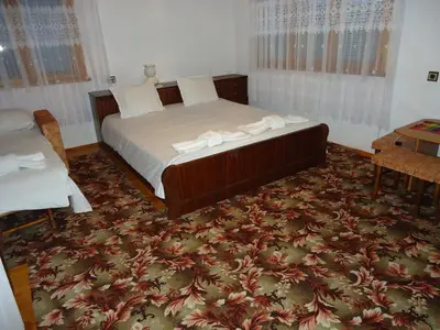 a bedroom with a large bed and a table at Guest House AHP in Mala Tsŭrkva