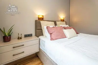 a bedroom with a white bed and a dresser at Urban Oasis Sofia in Sofia