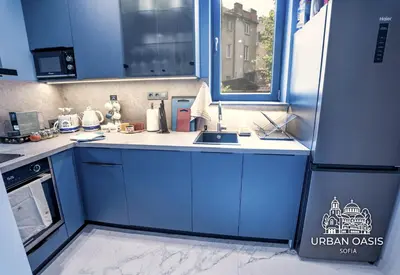 a kitchen with blue cabinets and a sink at Urban Oasis Sofia in Sofia