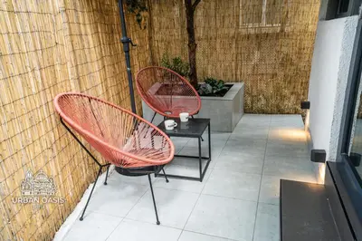 two red chairs and a table on a patio at Urban Oasis Sofia in Sofia