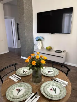 a table with plates and a vase of flowers on it at Kapana by V2 in Plovdiv