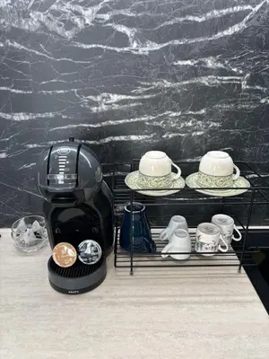 a coffee maker on a shelf with plates and cups at Kapana by V2 in Plovdiv