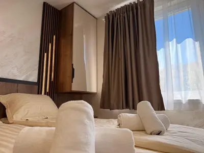 a hotel room with two beds and a window at Serenity Suites in Gotse Delchev