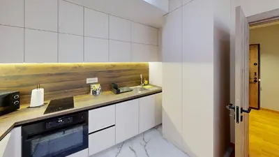 a kitchen with white cabinets and a sink and a stove at Cozy Central 1BDR Apartment Sofia near Mall Sofia and metro in Sofia