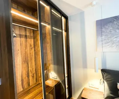 a room with a wooden wall and a glass partition at Cozy Central 1BDR Apartment Sofia near Mall Sofia and metro in Sofia