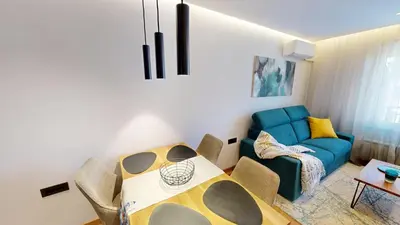 a living room with a table and a blue couch at Stylish Sofia Getaway 1BDR near Mall Sofia and metro station in Sofia