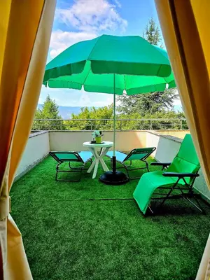 a patio with a table and chairs and an umbrella at Апартамент- Студио Кокетно in Sandanski