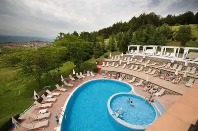 an overhead view of a swimming pool with chairs and umbrellas at Апартамент- Студио Кокетно in Sandanski