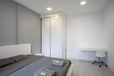 a bedroom with a bed and a desk and a chair at blueWave.place Sofia in Sofia