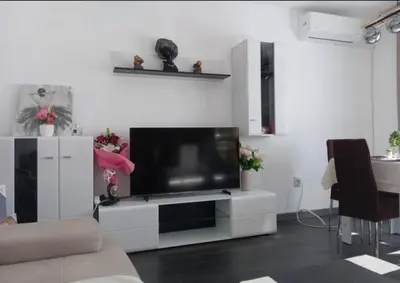 a living room with a television on a white entertainment center at Double next to NBU and Merto station, free parking in Sofia