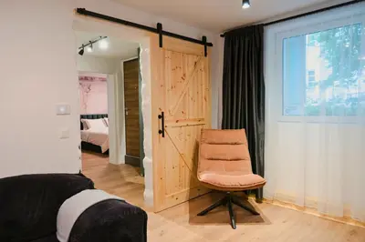 a bedroom with a chair and a sliding door at Quiet & Stylish Apartment in Central Sofia in Sofia