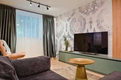 a living room with a couch and a flat screen tv at Quiet & Stylish Apartment in Central Sofia in Sofia