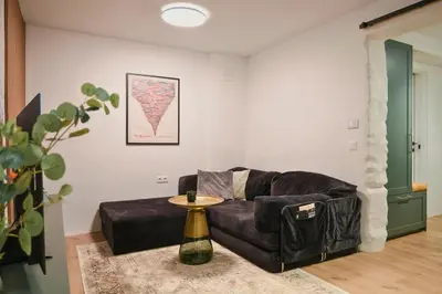 a living room with a black couch and a table at Quiet & Stylish Apartment in Central Sofia in Sofia