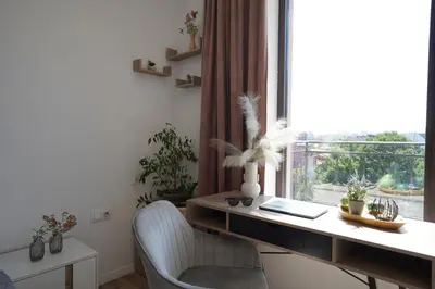 an office with a desk and chair with a window at Cozy place with free parking in Sofia