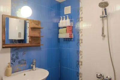 a blue bathroom with a shower and a sink at Dream Hill Nest-Boho Vintage Hideaway in Plovdiv