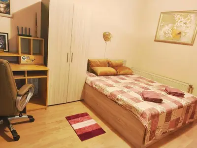 a bedroom with a bed and a desk and a chair at Самостоятелна къща за гости Трояна in Troyan